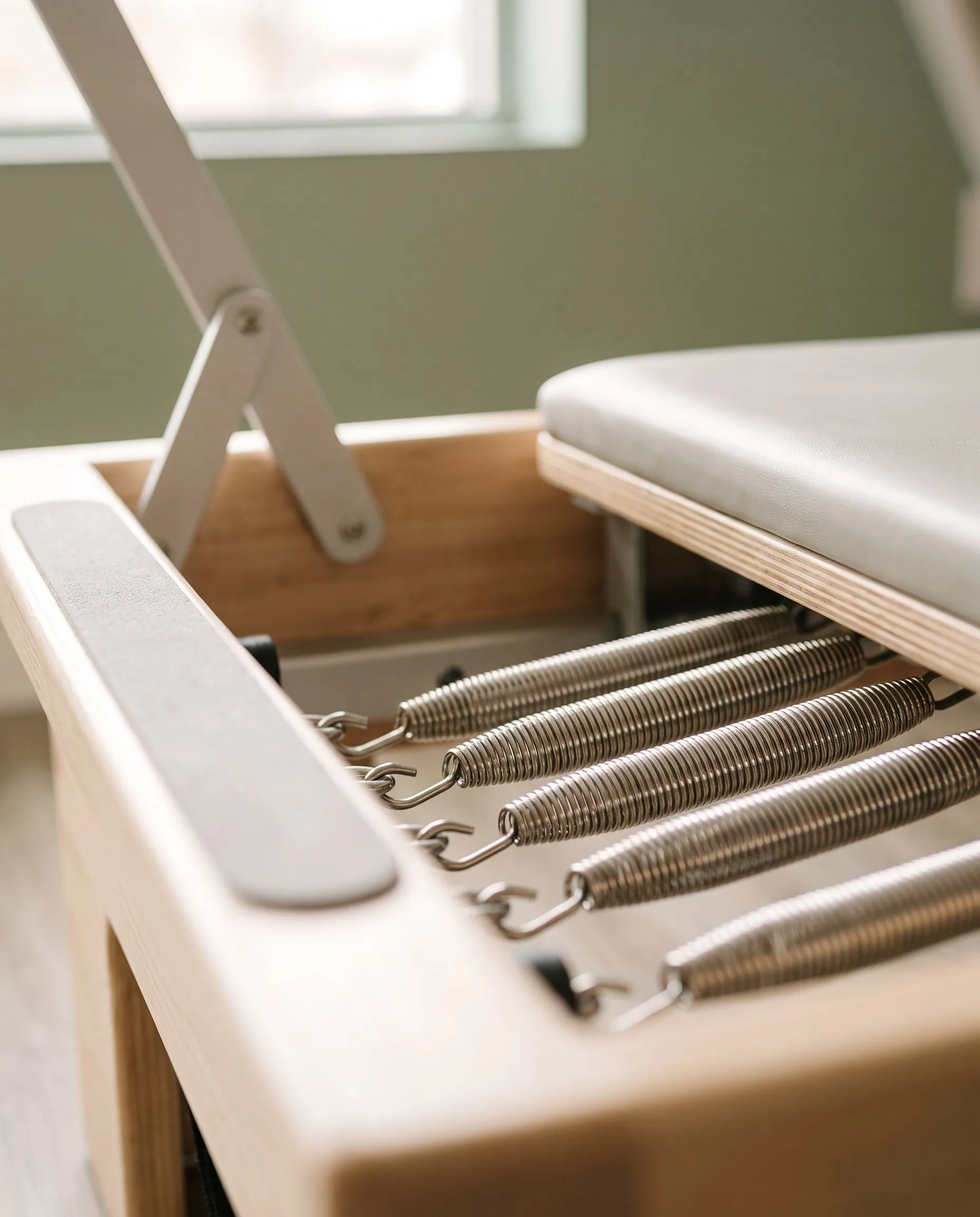 Close up of the springs and footbar on a timber Pilates reformer