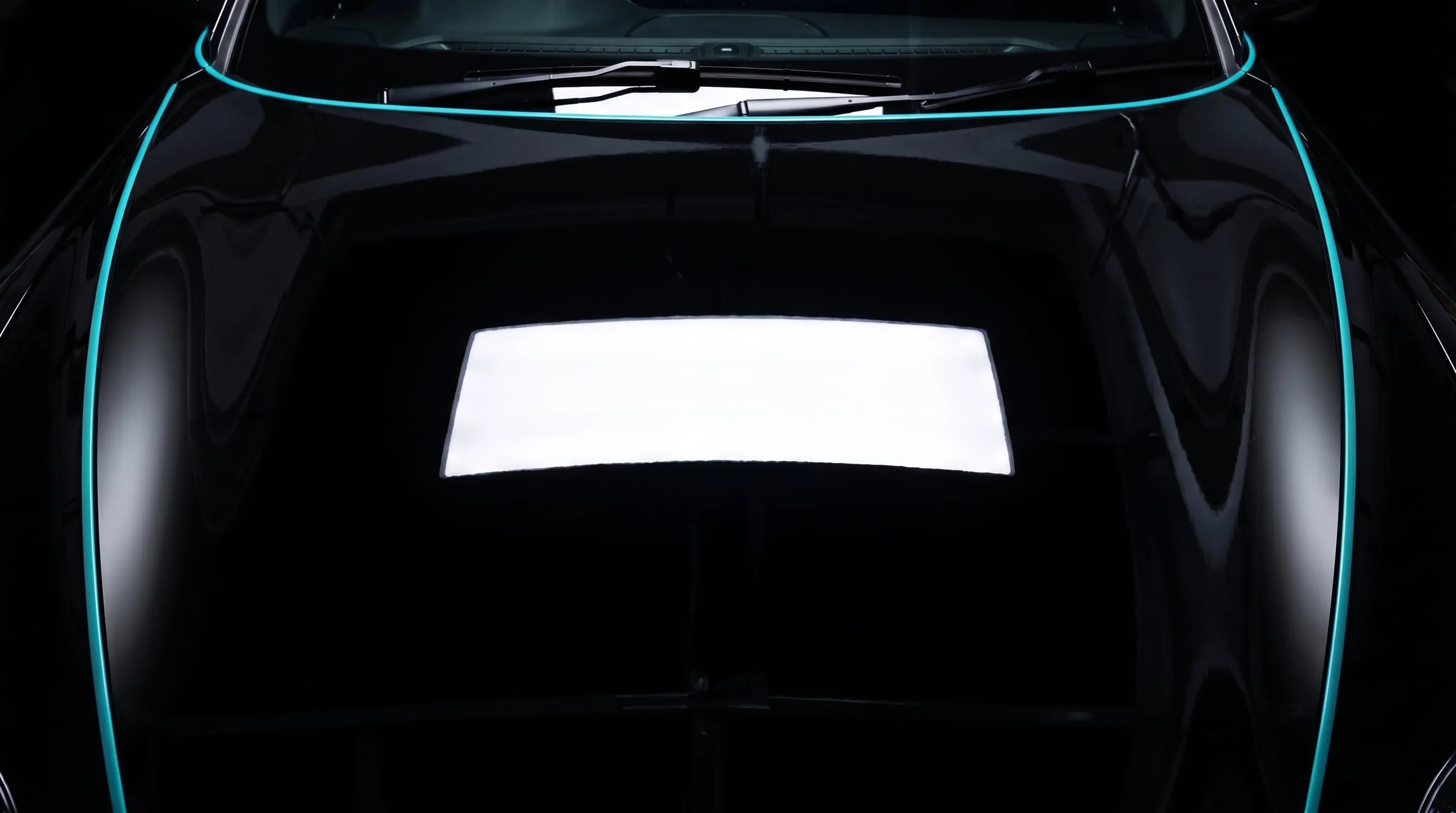 The same black bonnet after correction, the LED light reflected as a clean, sharp shape